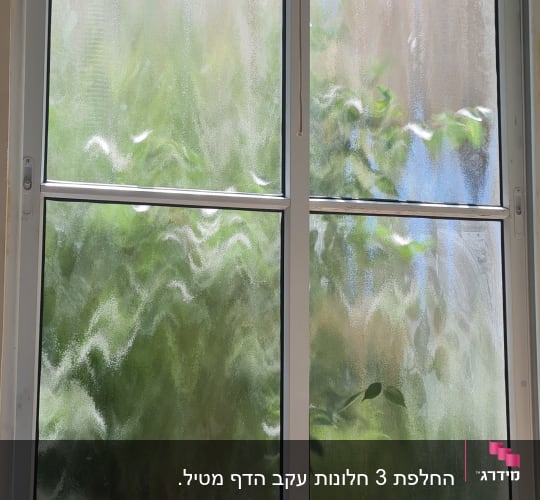 חלון עם זכוכית מטושטשת ושולחן עץ קטן